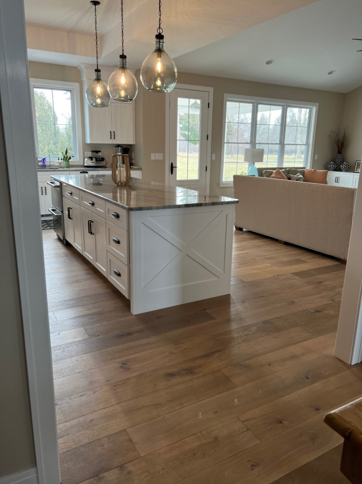 Large traditional l-shaped eat-in kitchen in Chicago with a double-bowl sink, beaded inset cabinets, white cabinets, granite benchtops, beige splashback, granite splashback, stainless steel appliances, medium hardwood floors, with island, multi-coloured floor, grey benchtop and vaulted.