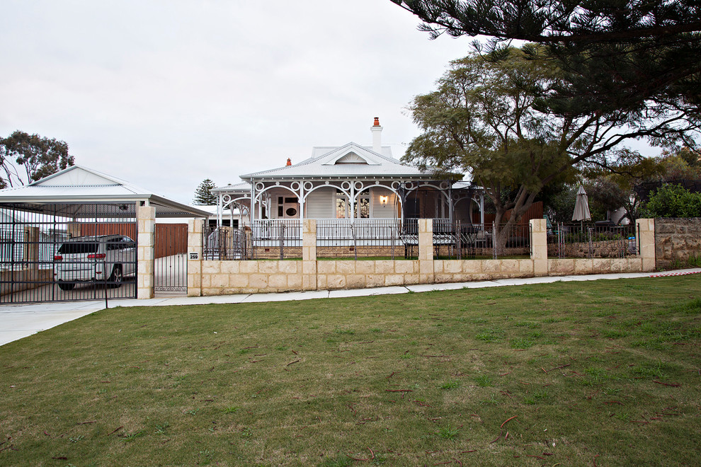 This is an example of a traditional two-storey white house exterior in Perth with wood siding, a hip roof and a metal roof.