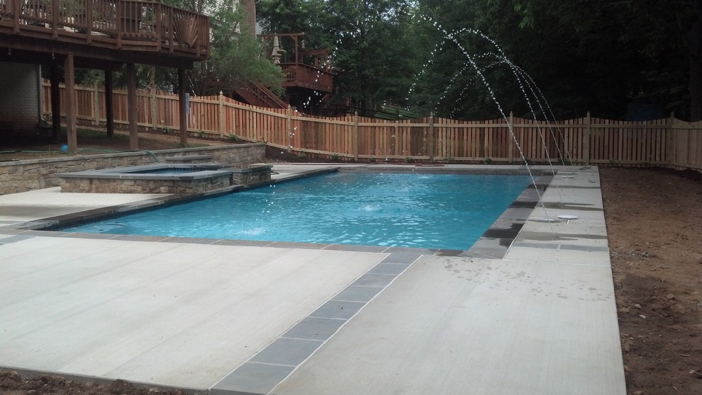 Pool fountain - mid-sized backyard concrete paver and custom-shaped pool fountain idea in DC Metro