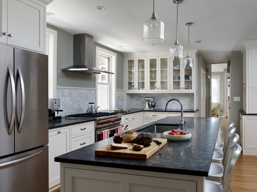 This is an example of a traditional l-shaped kitchen in Philadelphia with beaded inset cabinets, stainless steel appliances, a single-bowl sink, white cabinets, white splashback and marble splashback.