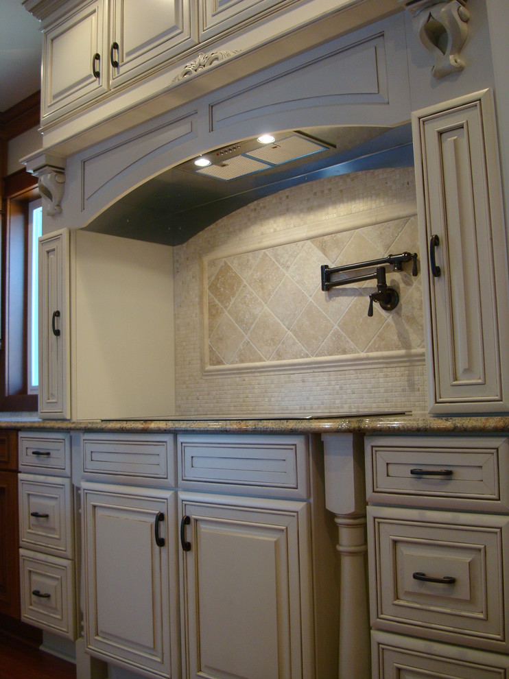 This is an example of a mid-sized traditional u-shaped eat-in kitchen in Seattle with a farmhouse sink, raised-panel cabinets, beige cabinets, granite benchtops, beige splashback, porcelain splashback, stainless steel appliances, medium hardwood floors and multiple islands.