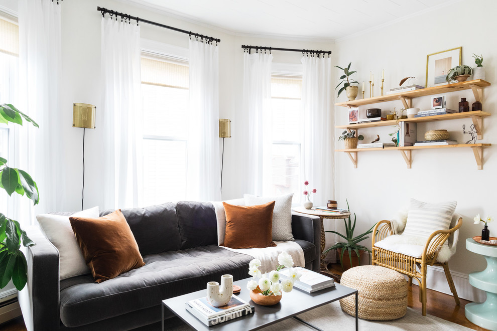 Inspiration for an eclectic living room in Boston with white walls, a library, medium hardwood floors and no fireplace.