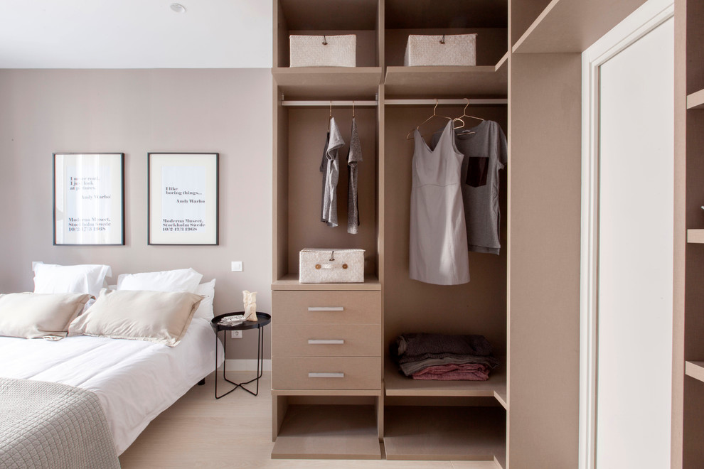 Design ideas for a small contemporary gender-neutral built-in wardrobe in Madrid with open cabinets and beige cabinets.