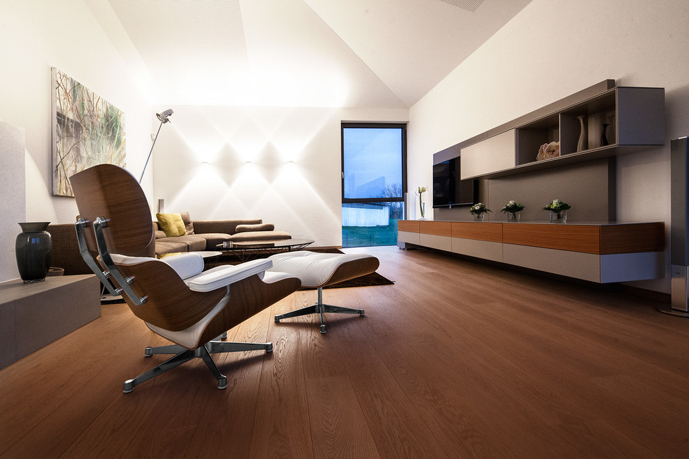 Offenes Modernes Wohnzimmer mit dunklem Holzboden und TV-Wand in München