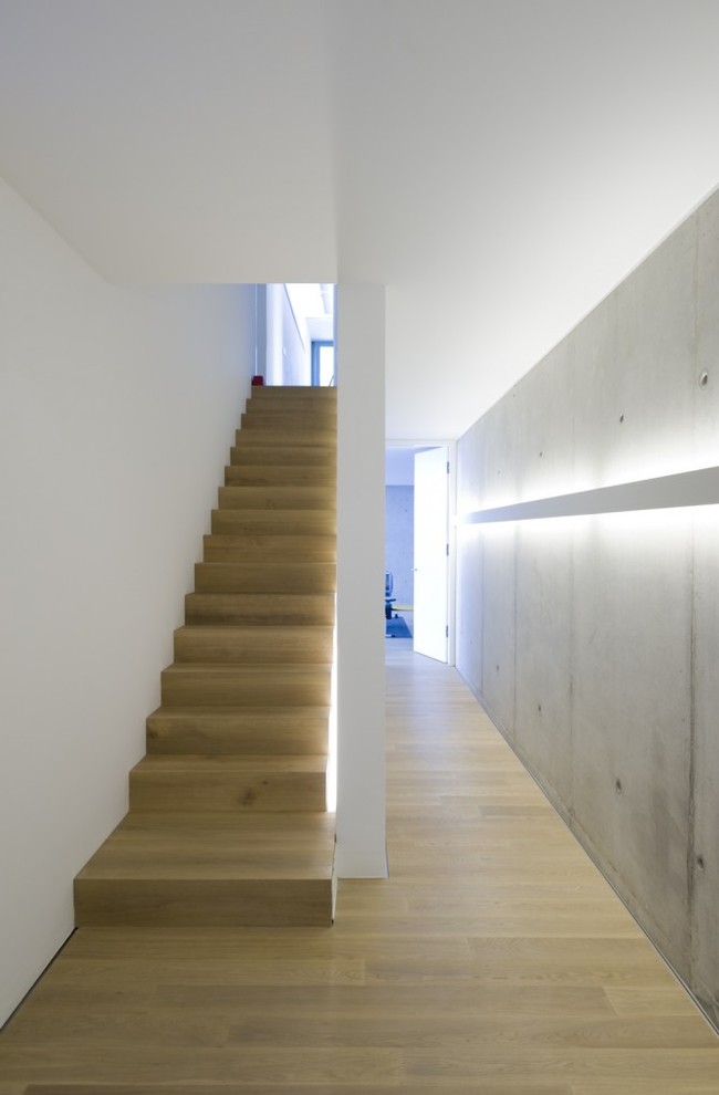 Mid-sized contemporary wood straight staircase in Munich with wood risers.