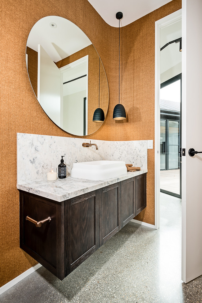 Mid-sized contemporary powder room in Melbourne with shaker cabinets, dark wood cabinets, brown walls, concrete floors, a vessel sink, marble benchtops, grey floor and grey benchtops.