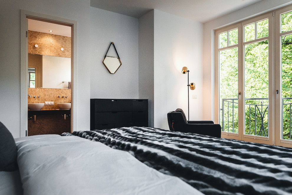 Hauptschlafzimmer mit weißer Wandfarbe, braunem Holzboden und braunem Boden in Berlin