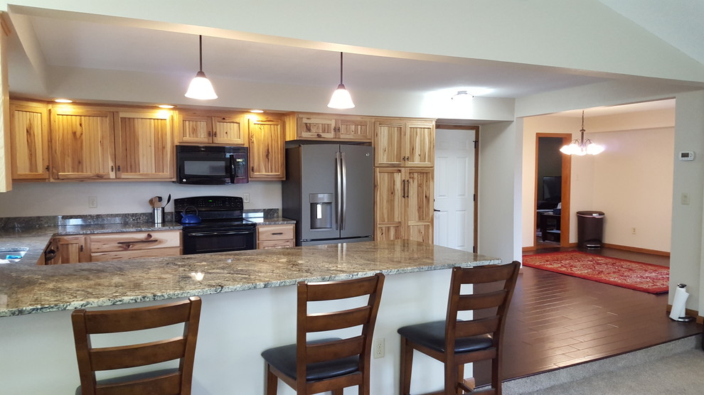 Example of an u-shaped dark wood floor eat-in kitchen design with an undermount sink, stainless steel appliances and a peninsula