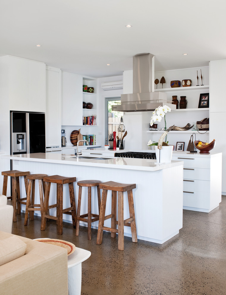 Photo of a mid-sized contemporary galley kitchen in Melbourne with flat-panel cabinets, white cabinets, with island, a double-bowl sink and concrete floors.