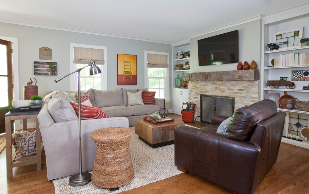 This is an example of a transitional living room in Atlanta with grey walls, a standard fireplace and a wall-mounted tv.