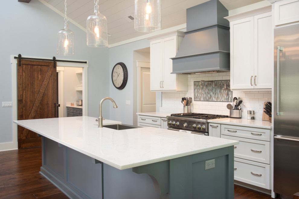 Inspiration for a large transitional galley medium tone wood floor and brown floor open concept kitchen remodel with a farmhouse sink, shaker cabinets, blue cabinets, quartz countertops, white backsplash, ceramic backsplash, stainless steel appliances, an island and white countertops