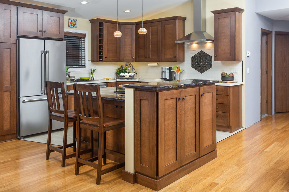 Mid-sized transitional l-shaped open concept kitchen photo with recessed-panel cabinets, dark wood cabinets, quartz countertops, white backsplash, subway tile backsplash, stainless steel appliances and an island