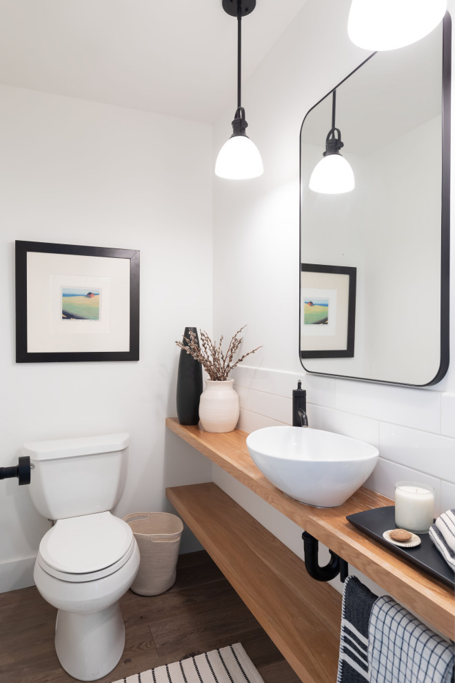Transitional powder room in Seattle with light wood cabinets, a two-piece toilet, white walls, a vessel sink, wood benchtops, brown floor, white tile, ceramic tile and open cabinets.
