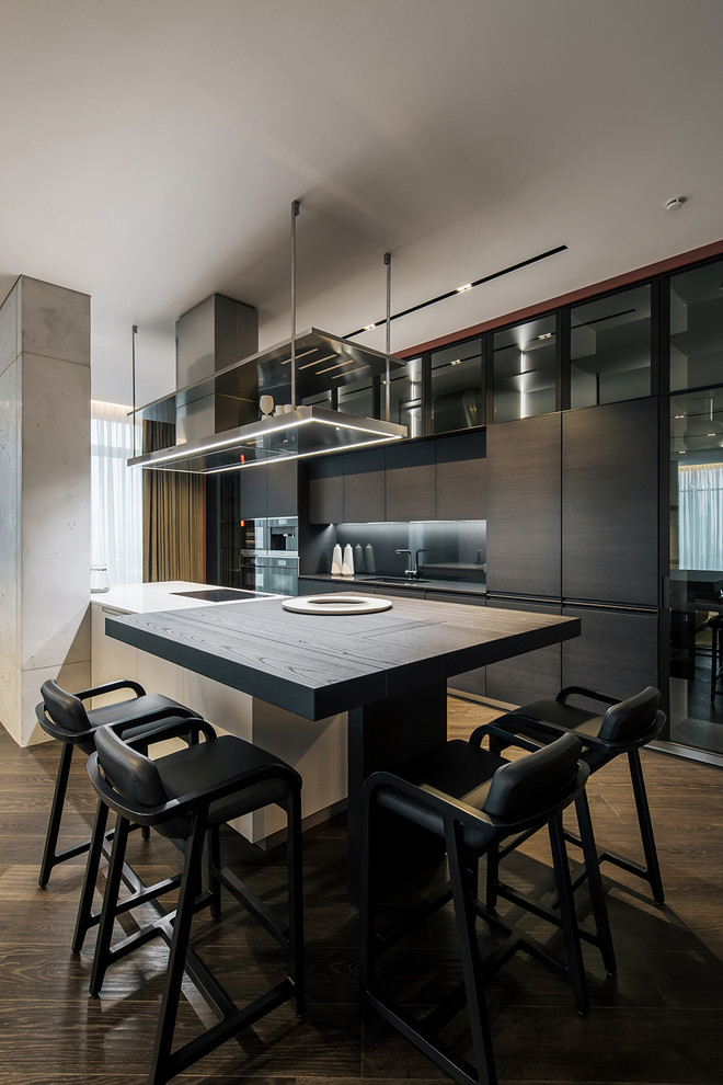 This is an example of a contemporary galley kitchen in Miami with flat-panel cabinets, black cabinets, wood benchtops, dark hardwood floors, with island, brown floor and brown benchtop.