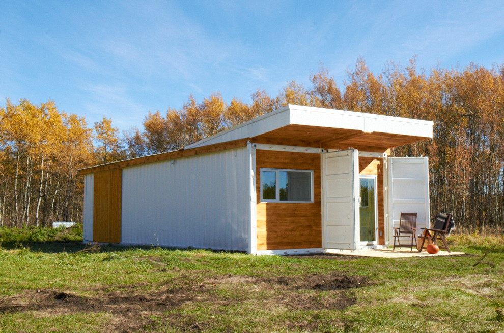 Photo of a small modern one-storey white exterior in Calgary with metal siding and a flat roof.