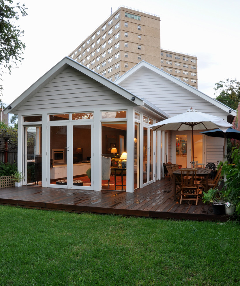 Design ideas for a mid-sized modern white house exterior in Geelong with wood siding, a gable roof and a metal roof.