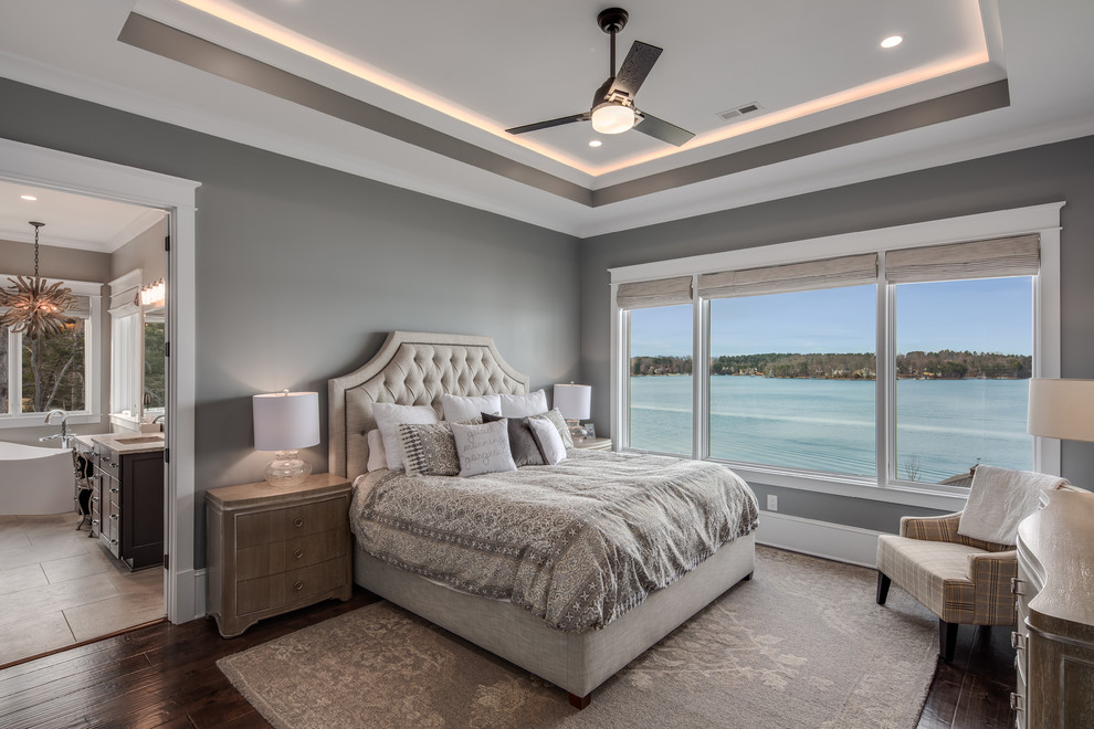 Mid-sized country master bedroom in Other with grey walls, medium hardwood floors and brown floor.