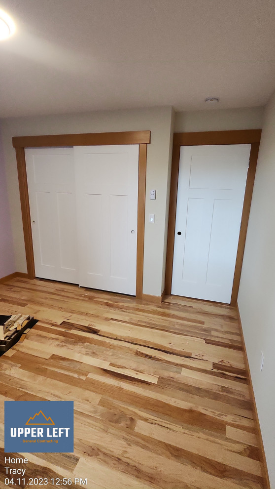 Diseño de dormitorio abovedado de estilo americano de tamaño medio con paredes blancas y suelo de madera clara