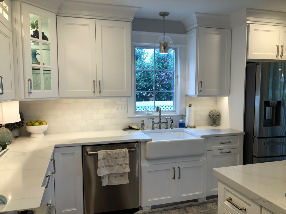 Large transitional l-shaped medium tone wood floor and brown floor eat-in kitchen photo in Baltimore with a farmhouse sink, flat-panel cabinets, white cabinets, quartz countertops, white backsplash, subway tile backsplash, stainless steel appliances, an island and white countertops