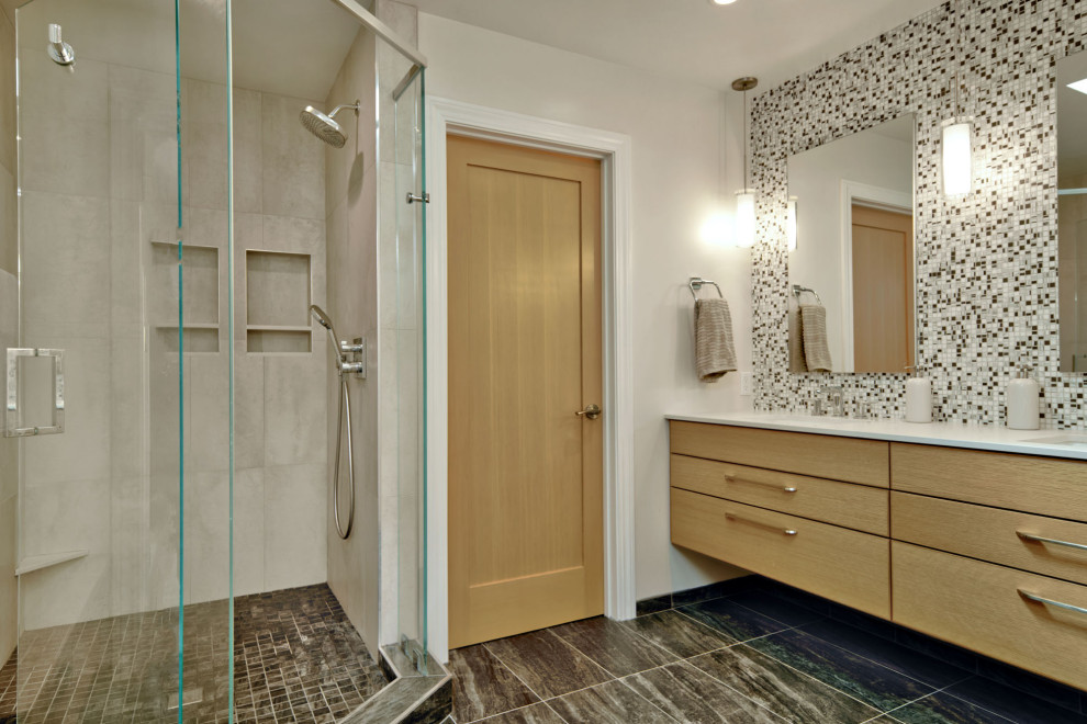 Idées déco pour une salle de bain contemporaine en bois clair de taille moyenne avec un placard à porte plane, une douche d'angle, un carrelage noir et blanc, mosaïque, un mur gris, un sol en carrelage de porcelaine, un lavabo encastré, un sol gris, une cabine de douche à porte battante, un plan de toilette blanc, des toilettes cachées, meuble double vasque, meuble-lavabo suspendu et un plan de toilette en quartz modifié.
