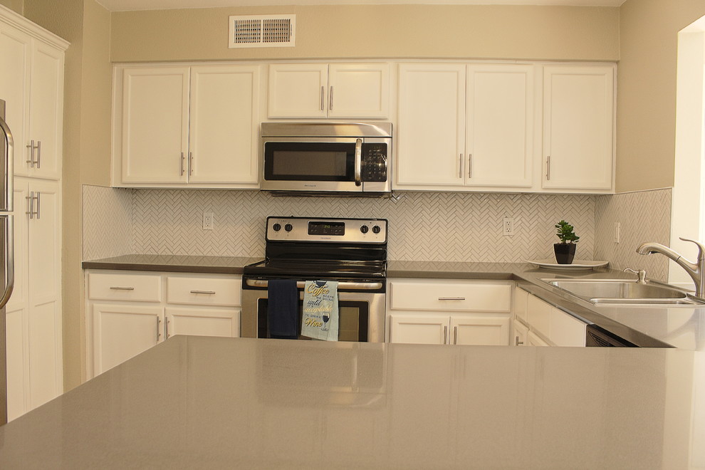Inspiration for a small transitional l-shaped terra-cotta tile eat-in kitchen remodel in Phoenix with a drop-in sink, shaker cabinets, white cabinets, quartzite countertops, white backsplash, mosaic tile backsplash, stainless steel appliances and a peninsula