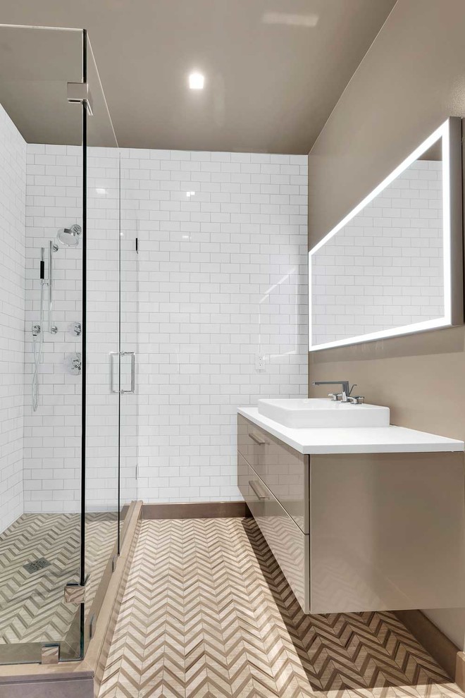 Inspiration for a small modern master bathroom in New York with a hinged shower door, flat-panel cabinets, beige cabinets, a corner shower, a wall-mount toilet, white tile, porcelain tile, beige walls, ceramic floors, a wall-mount sink, engineered quartz benchtops, beige floor and white benchtops.