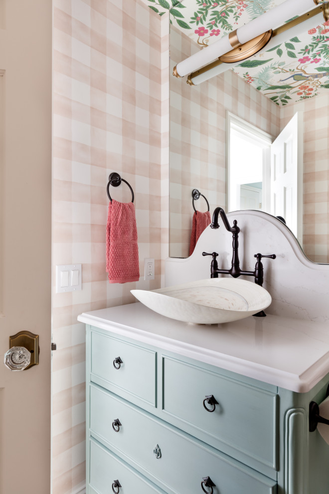 This is an example of a small cloakroom in Seattle with turquoise cabinets, a one-piece toilet, pink tiles, pink walls, medium hardwood flooring, a vessel sink, engineered stone worktops, brown floors, white worktops, a freestanding vanity unit, a wallpapered ceiling and wallpapered walls.