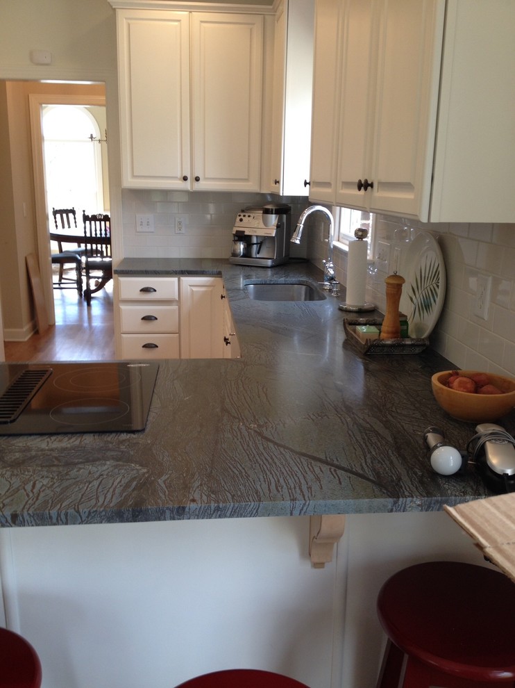 Kitchen - light wood floor kitchen idea with soapstone countertops, white backsplash and ceramic backsplash