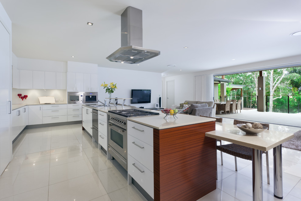 Design ideas for a large modern l-shaped open plan kitchen in Philadelphia with an undermount sink, flat-panel cabinets, white cabinets, white splashback, stainless steel appliances, with island and linoleum floors.