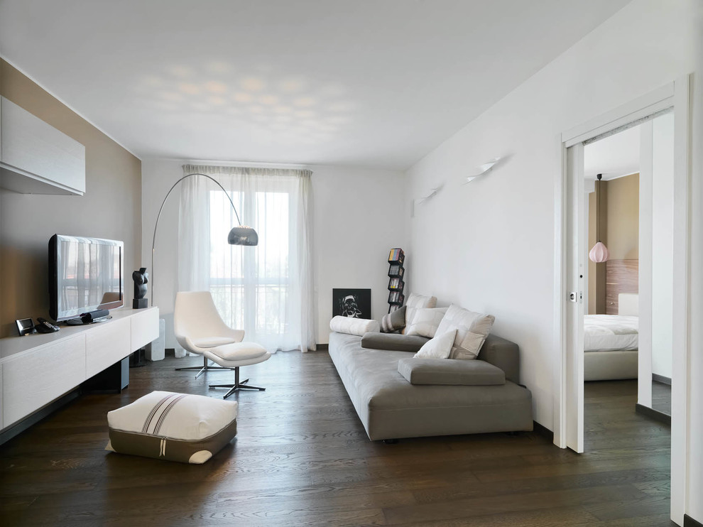 Photo of a mid-sized contemporary enclosed living room in Milan with white walls and dark hardwood floors.