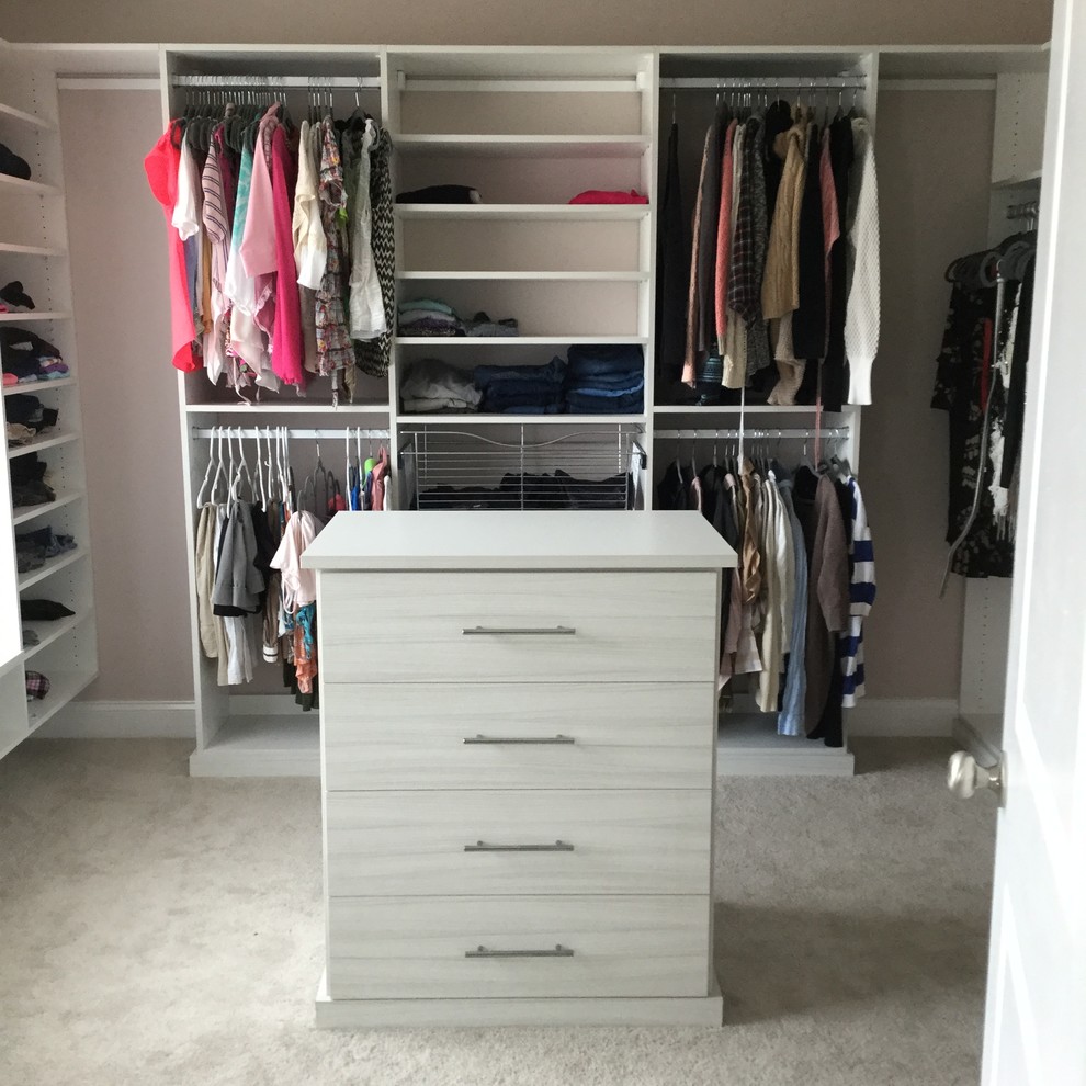 Design ideas for a large transitional women's walk-in wardrobe in New York with flat-panel cabinets, white cabinets and carpet.