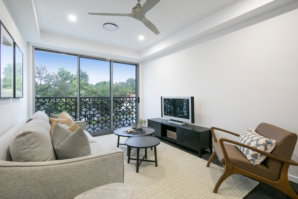 This is an example of a large contemporary open concept living room in Brisbane with white walls, carpet, no fireplace, a freestanding tv and black floor.