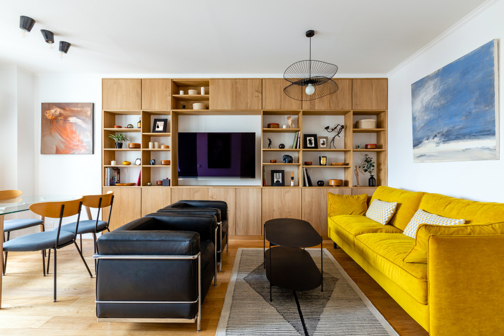 Источник вдохновения для домашнего уюта: открытая гостиная комната в современном стиле с белыми стенами, телевизором на стене и коричневым полом без камина