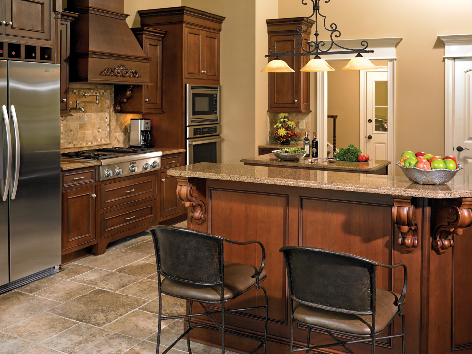 Inspiration for a large transitional single-wall porcelain tile and beige floor enclosed kitchen remodel with an undermount sink, recessed-panel cabinets, dark wood cabinets, granite countertops, beige backsplash, porcelain backsplash, stainless steel appliances, an island and multicolored countertops