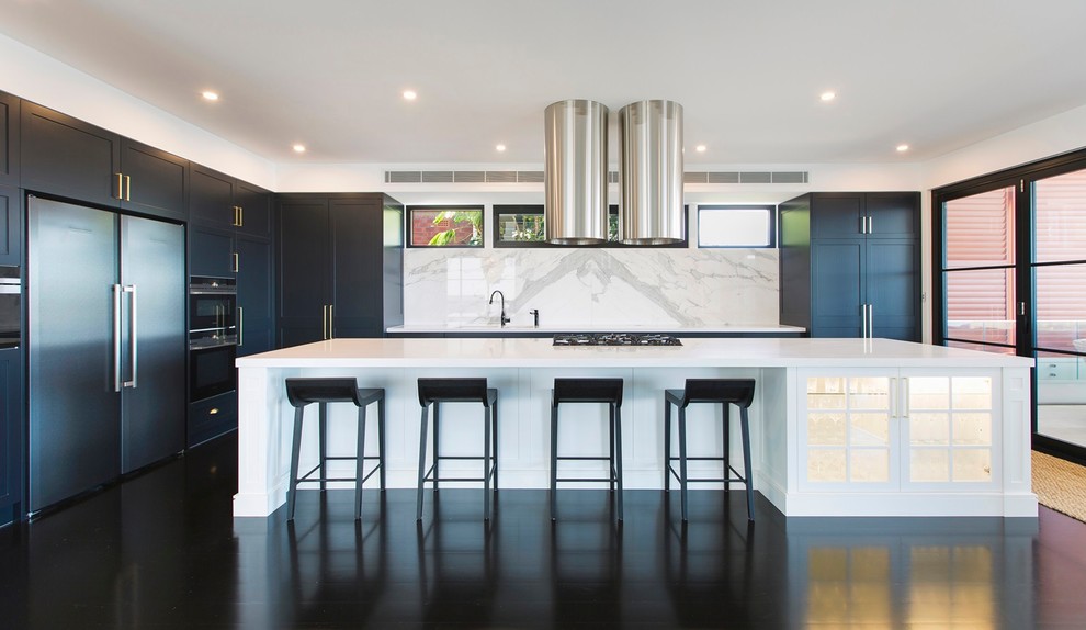 Design ideas for a large traditional l-shaped eat-in kitchen in Newcastle - Maitland with an undermount sink, shaker cabinets, white cabinets, solid surface benchtops, white splashback, marble splashback, black appliances, painted wood floors, with island, black floor and white benchtop.