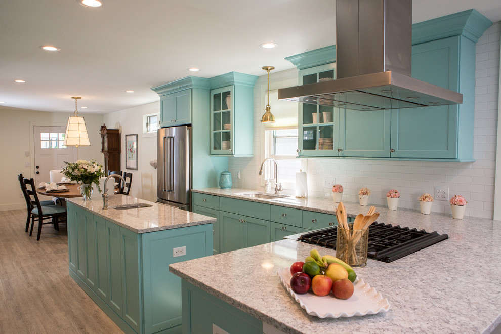 Photo of a small beach style l-shaped eat-in kitchen in Other with an undermount sink, flat-panel cabinets, turquoise cabinets, quartz benchtops, white splashback, ceramic splashback, stainless steel appliances, vinyl floors, with island and grey floor.