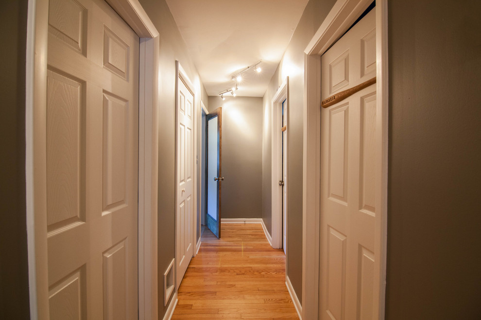 Example of a mid-sized transitional light wood floor and brown floor hallway design in Atlanta with gray walls