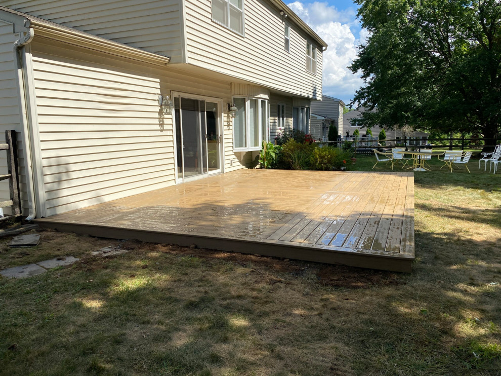 Photo of a backyard and ground level deck in Philadelphia with no cover.