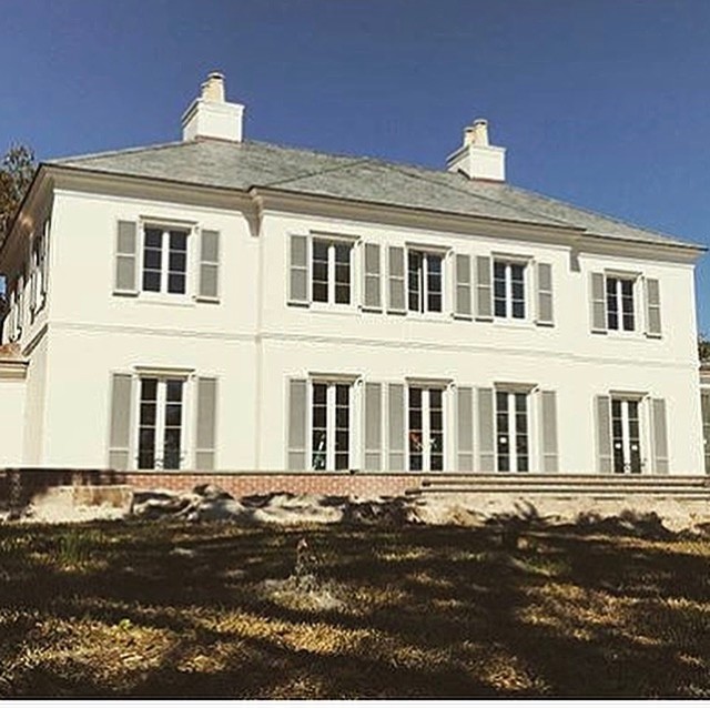 Photo of a large traditional two-storey stucco white house exterior in Atlanta with a gable roof and a shingle roof.