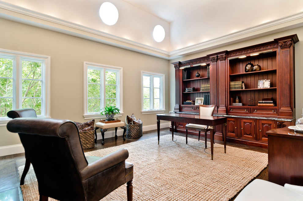 Large traditional study room in Chicago with white walls, dark hardwood floors and a freestanding desk.