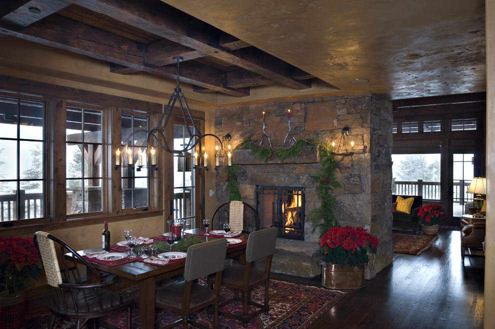 Country dining room in Other with a stone fireplace surround.