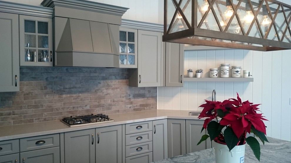 Mid-sized transitional single-wall kitchen photo in Toronto with an undermount sink, recessed-panel cabinets, gray cabinets, quartz countertops, gray backsplash, stone tile backsplash, stainless steel appliances and an island