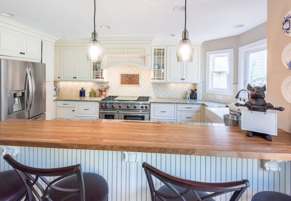 Transitional medium tone wood floor kitchen photo in Richmond with a farmhouse sink, raised-panel cabinets, granite countertops, beige backsplash, stone tile backsplash, stainless steel appliances and white cabinets