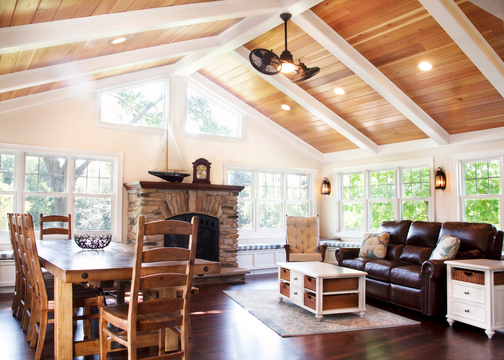 Large transitional sunroom in Milwaukee with dark hardwood floors, a standard fireplace, a stone fireplace surround, a standard ceiling and brown floor.