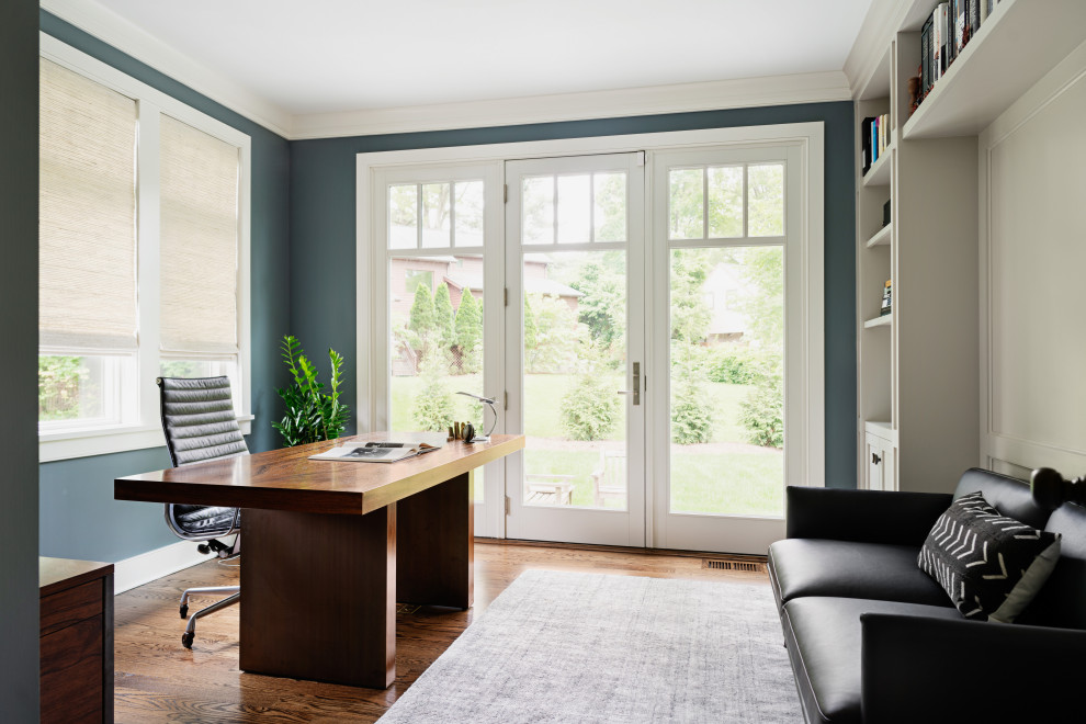 Inspiration for a mid-sized transitional medium tone wood floor home office remodel in New York with blue walls