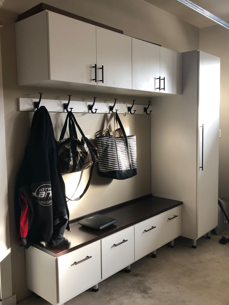 This is an example of a large country gender-neutral built-in wardrobe in Other with shaker cabinets, white cabinets, carpet and beige floor.