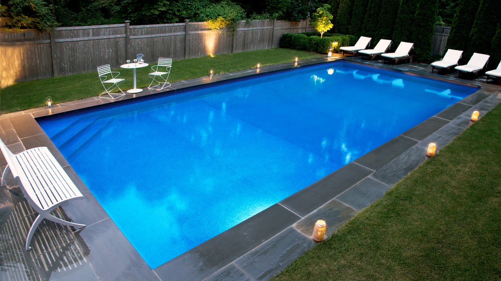 Example of a large tuscan backyard stone and rectangular pool design in New York
