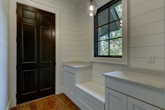 Front door - mid-sized rustic medium tone wood floor and brown floor front door idea with white walls