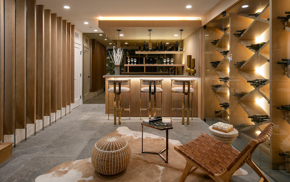 Beach style seated home bar in Los Angeles with open cabinets, light wood cabinets and grey floor.