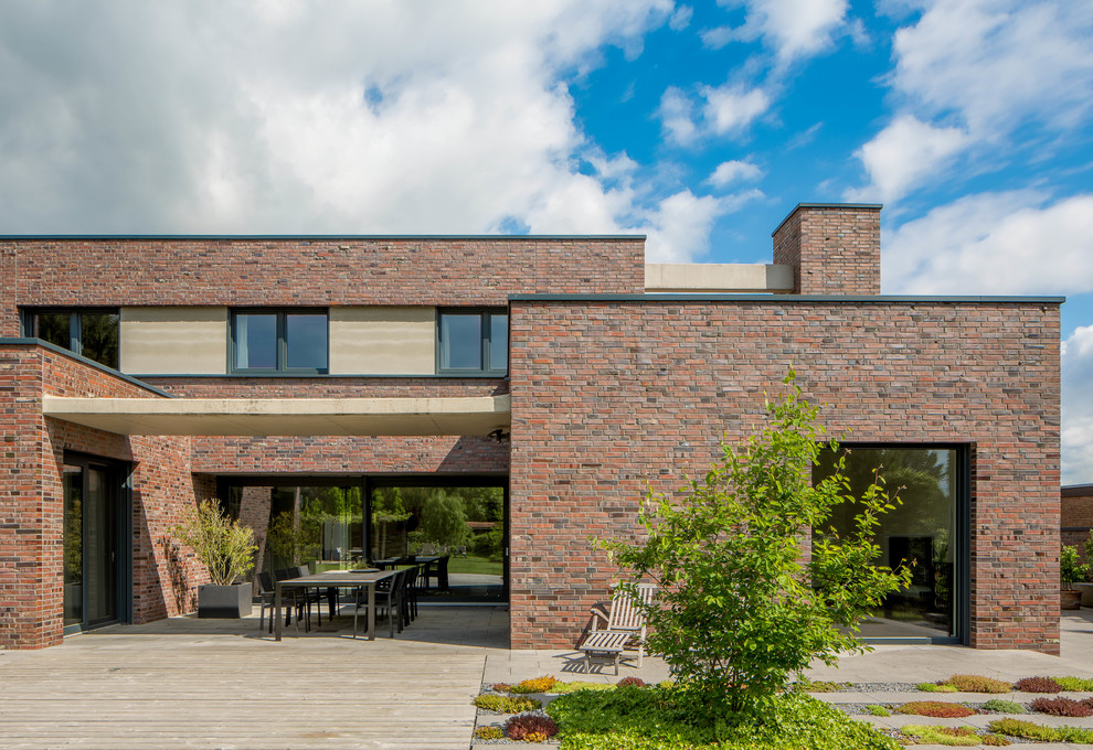 Inspiration for a large contemporary two-storey brick multi-coloured exterior in Dusseldorf with a flat roof.